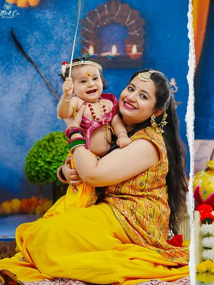 A heartwarming hug between a mother and her baby, both dressed in beautiful traditional attire for the Krishna-themed shoot.