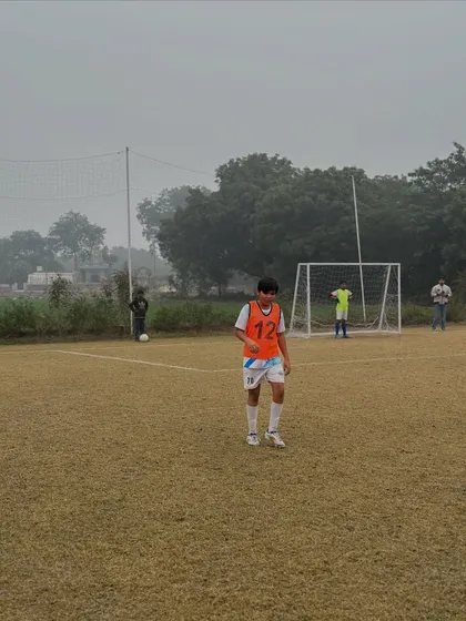 A young player on our full-size grass pitch during a training match. We provide a professional environment for players to develop from a young age.