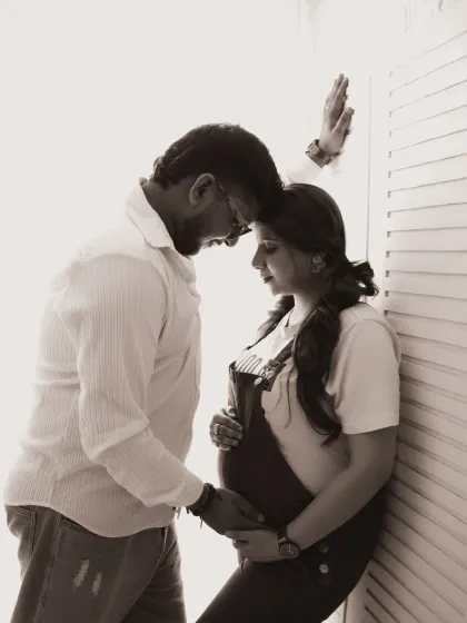 An emotional and intimate black and white portrait. The couple shares a quiet moment, their connection beautifully highlighted by the soft, directional light.