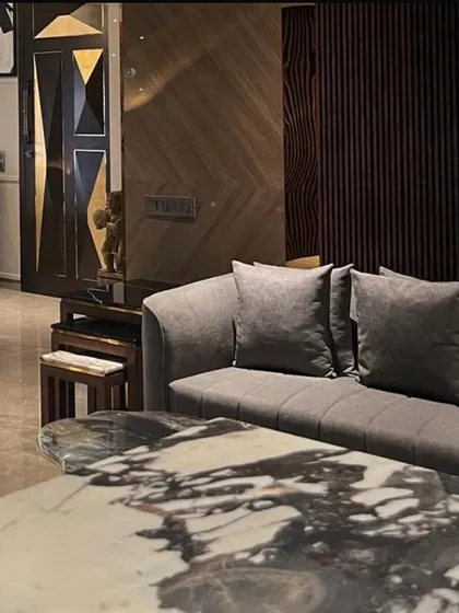 We believe luxury is found in the details. This composition from a Juhu apartment highlights a custom marble coffee table, the rich texture of the sofa, and a bespoke geometric door, demonstrating our commitment to curated, high-quality finishes.