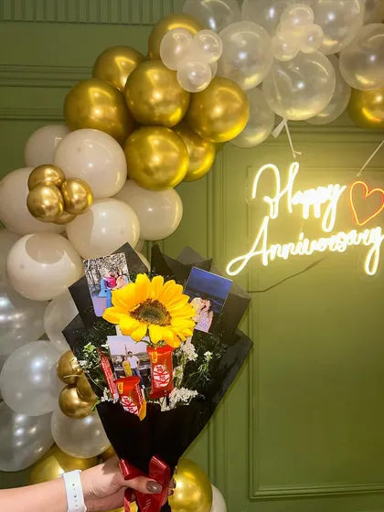 I can also arrange for custom bouquets to match the decor, like this one with a sunflower and personal photos for an anniversary gift.