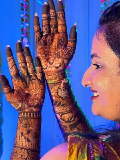 A candid shot of a bride admiring her intricate mehendi. The deep stain from my organic henna is clearly visible, ensuring a beautiful look for her wedding photos.