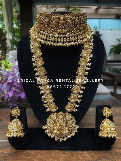 An elegant all-gold look temple set. This rental piece features a wide choker and a long haram with Lakshmi motifs, finished with delicate pearls.