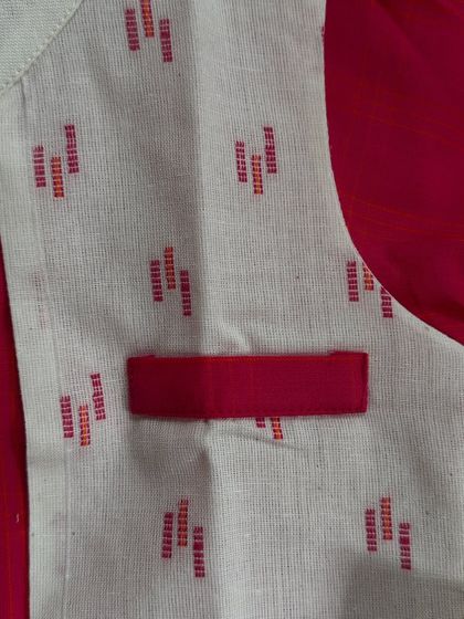 A close-up of the pocket and fabric of our red kurta and Nehru jacket set, highlighting the clean stitching and woven texture.
