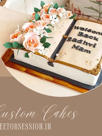 An exquisite cake designed as an open book, with delicate sugar flowers spilling from the pages, perfect for a "welcome back" celebration.