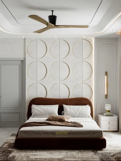 The bed wall of the Apex D'Rio master bedroom, showcasing the unique circular paneling and a curved, upholstered headboard. The design is modern, soft, and visually interesting.