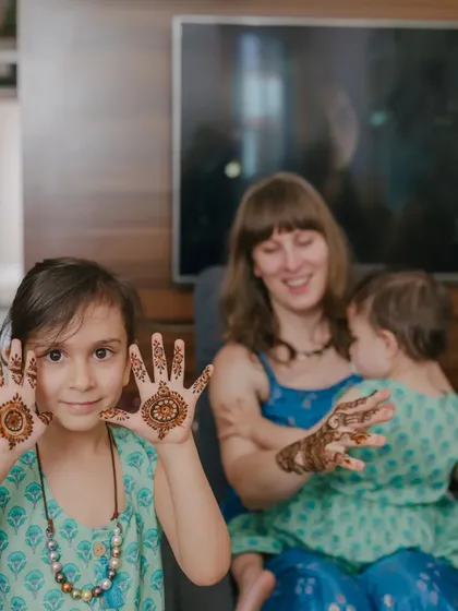A sweet moment with a young client proudly showing off her very first mandala mehndi designs.