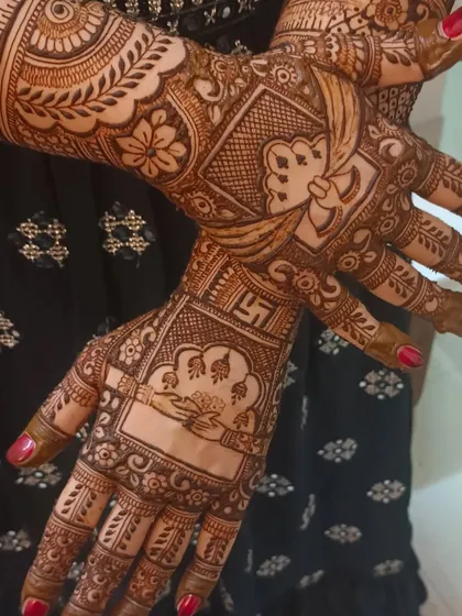A closer look at the auspicious wedding symbols, including the swastika and 'kanyadaan' hands, integrated into a bridal design.