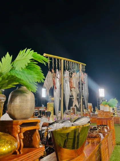 The seafood station, elegantly arranged with fresh fish and palm fronds, set against the backdrop of the night sky.