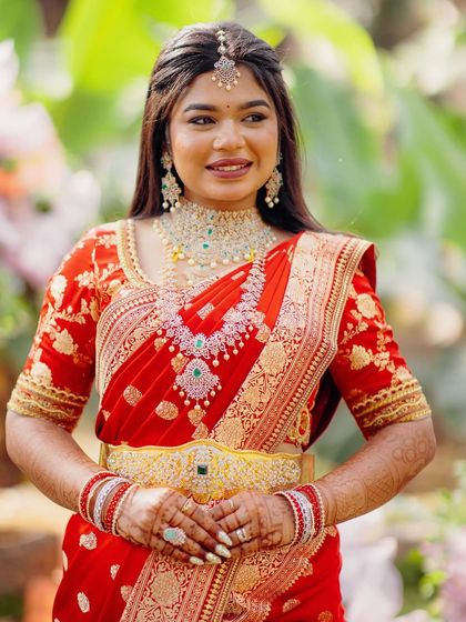 Another beautiful portrait of the bride in her red saree, showcasing her diamond jewelry and radiant smile.