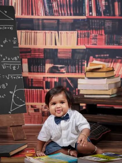 A different angle of our little scholar, capturing his adorable expression as he explores the books in his 'library'.