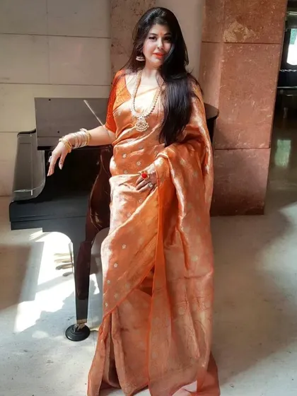 A full-length view of the stunning orange trousseau saree. The way the fabric drapes is incredibly flattering, and when paired with the right jewellery, it creates an unforgettable, regal look.