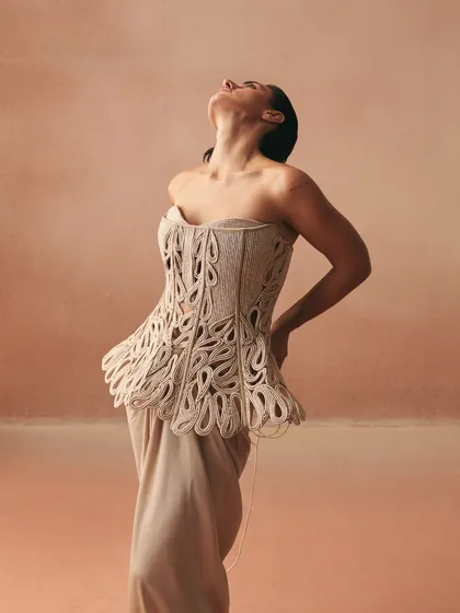 An expressive pose in the Karov corset, highlighting how the sculpted cutwork binds the bodice with echoes of ties we carry.
