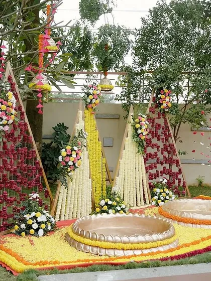 Another angle of the Haldi ceremony area, showing the couple's seating placed on a bed of yellow flower petals. The entire space is bursting with color and joyful energy.