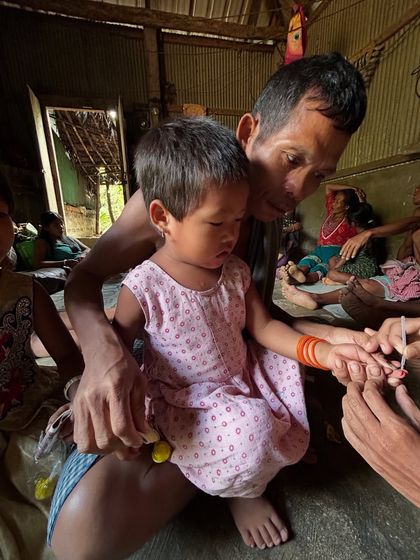 A young child getting a health check during one of our community visits. This is the reality of public health work, and it's a world I balance with my DJ career.