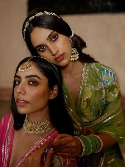 An intimate group portrait for Indian wear brand Ruhr India. The warm lighting and rich textures of the garments create a regal and atmospheric scene, highlighting traditional aesthetics with a modern sensibility.