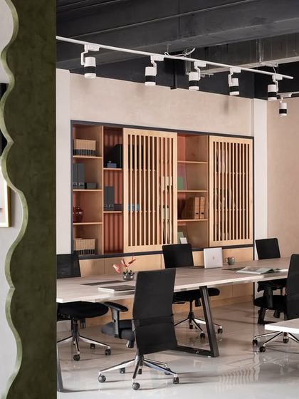 This partition wall serves a dual purpose. Aesthetically, its lime wash texture and scalloped edge provide a canvas for an evolving art gallery. Functionally, it holds large dashboards for my team to track project progress.