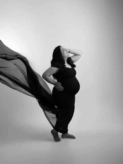 A powerful and confident pose in black and white. This profile shot emphasizes the beautiful silhouette of pregnancy, creating a strong and artistic image.