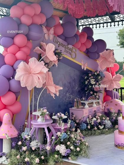 Another angle of the whimsical floral setup, highlighting the large balloon garland that frames the entire scene. The mix of florals, balloons, and custom props creates a rich, multi-layered look.