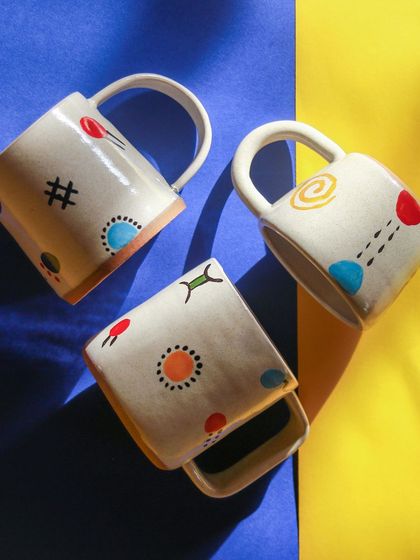 The 'Playful Mornings' collection by Varsha, featuring brightly colored, hand painted mugs with whimsical patterns designed to bring joy to your breakfast routine.
