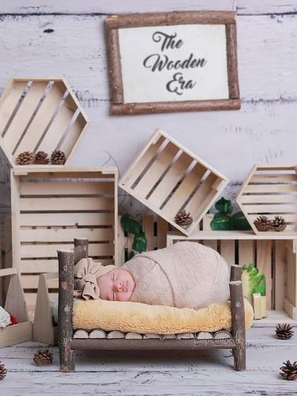 Our 'Wooden Era' theme, a full set composed of natural wood crates, pinecones, and a rustic log bed, creating a beautiful woodland scene.