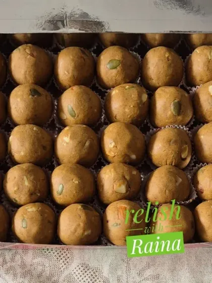 A box of Sattu Laddoos with pumpkin seeds visible on top. I often add seeds for extra crunch and nutritional benefits.