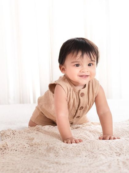 Now that's one timeless picture! A simple, beautiful shot of a baby crawling on a textured blanket, capturing a classic developmental milestone.