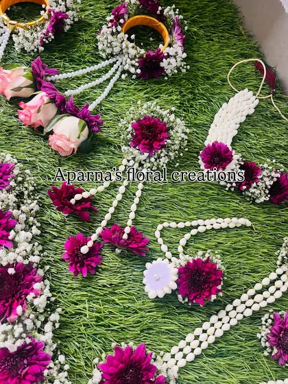 A detailed view of the necklace and earrings from the magenta and pink floral set.