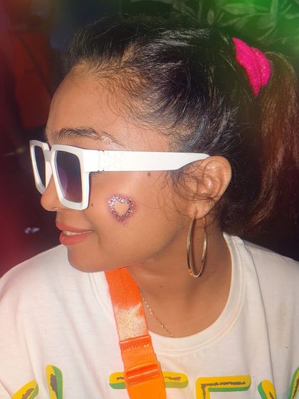 A cute and playful glitter heart tattoo on the cheek. I can create these using stencils for a perfect shape every time.