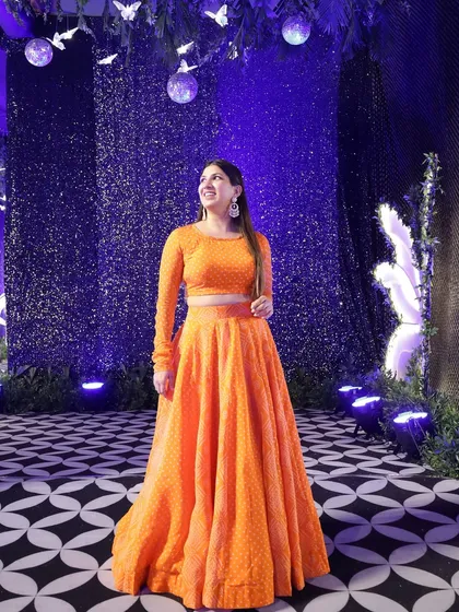 Posing against a beautifully lit purple backdrop. The decor and lighting at Sangeet events are often spectacular and make for great photos.