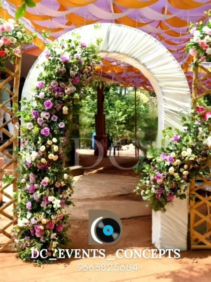 A creative entrance combining a rustic bamboo lattice with a classic floral arch. This design is perfect for an outdoor event, blending natural materials with elegant decor.