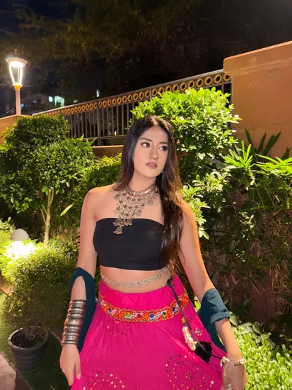 A close-up on the oxidized silver necklace and the colorful belt, key elements of the boho-ethnic look.