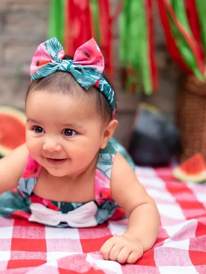 A perfect six-month milestone captured with a refreshing watermelon smash. This outdoor setup on a picnic blanket is a wonderful way to celebrate your baby sitting up and exploring new things.