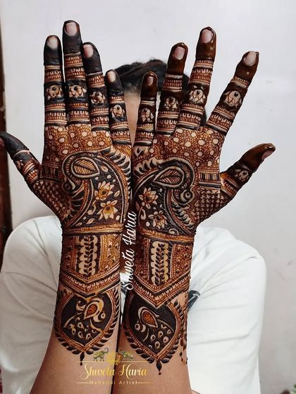 This back-hand design features a bold paisley and peacock theme, with delicate floral details on the fingers.