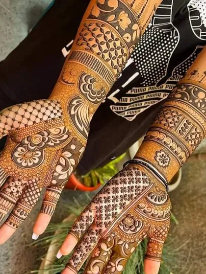 A contemporary take on bridal mehndi, with one arm featuring a traditional full design and the other a more modern, spaced-out pattern.