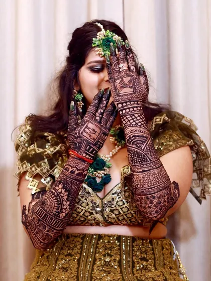 A playful "peek-a-boo" pose with the bride's henna-covered hands. These fun shots add personality to the Mehndi album.