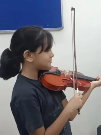 A young student practices the violin during a music class. Learning an instrument like the violin develops fine motor skills, discipline, and a deep appreciation for music.