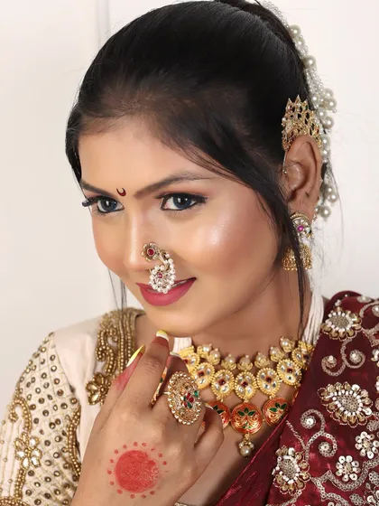 A detailed shot of the bridal jewellery, including the choker, nath, and the 'chooda' (green bangles) that are essential for a Maharashtrian bride.
