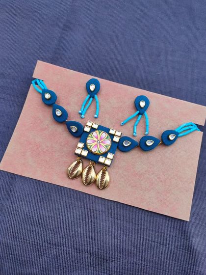A hand-painted necklace set with a unique floral motif. This choker-style necklace features Kundan work and cowrie shell charms, combining several of my favorite techniques.