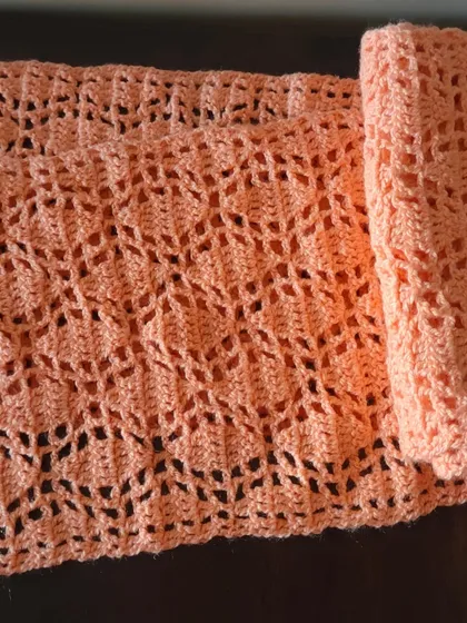 The Sharad Ritu scarf rolled up, showing its light and delicate texture.