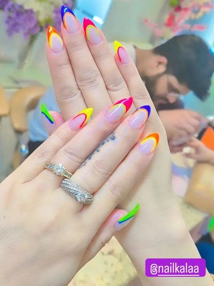 Another look at the rainbow French tip design, showcasing the clean lines and vibrant neon colors on each nail. This is a great example of a fun, custom French manicure.