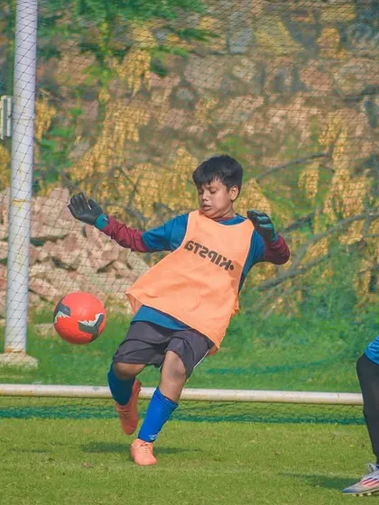 A goalkeeper makes a crucial save, blocking a shot during a tense moment in a Pride Cup game.