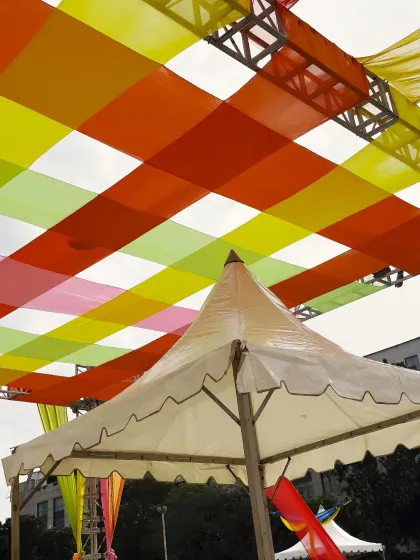 A close-up of the colorful overhead decor for a Dandiya night. I use a combination of trussing and vibrant fabric drapes to create a festive canopy, transforming an open space and adding to the celebratory atmosphere.