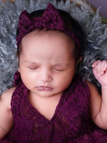 A duplicate of image 11, showcasing the rich color and delicate lace of the baby's outfit.