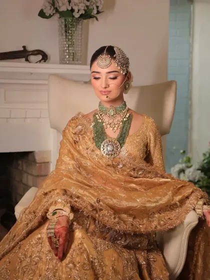 A moment of regal repose. I styled this bride in a magnificent golden lehenga, seated to showcase the rich texture and heavy embroidery, complemented by layered green beaded jewelry.