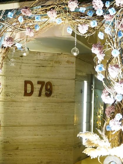 A whimsical entrance arch made of twisted branches and adorned with delicate blue and pink flowers. This created a magical entryway for guests arriving at the celebration.