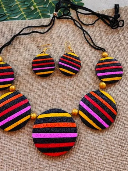 This version of the striped necklace uses a warmer palette of pink, orange, and yellow. The textured surface adds an interesting dimension to the simple geometric design.