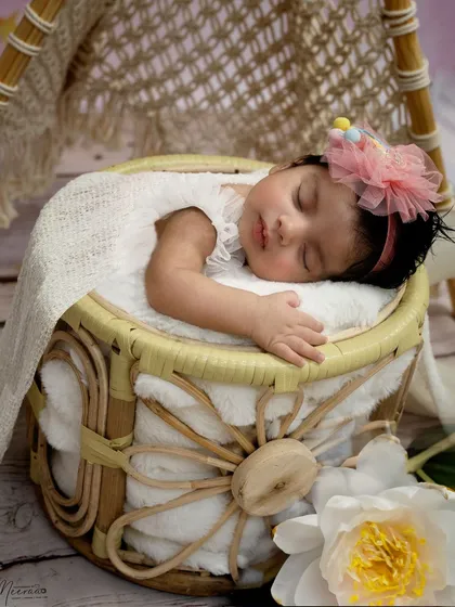 A perfect little princess sleeping in a cane basket. The best time to capture these sleepy, posable shots is within the first 5 to 20 days after birth.
