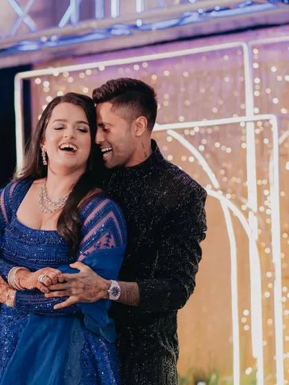 A candid shot of cricketer Surya Kumar Yadav sharing a laugh with his wife at his sister's engagement party.