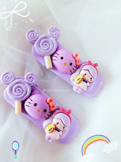 A sprinkle of kawaii magic. These purple hair clips feature a Hello Kitty-like character, a lollipop, and a little girl charm, perfect for a pastel aesthetic.